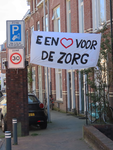 848712 Afbeelding van spandoek met de tekst 'EEN HART VOOR DE ZORG', opgehangen in de Ferdinand Bolstraat te Utrecht, ...